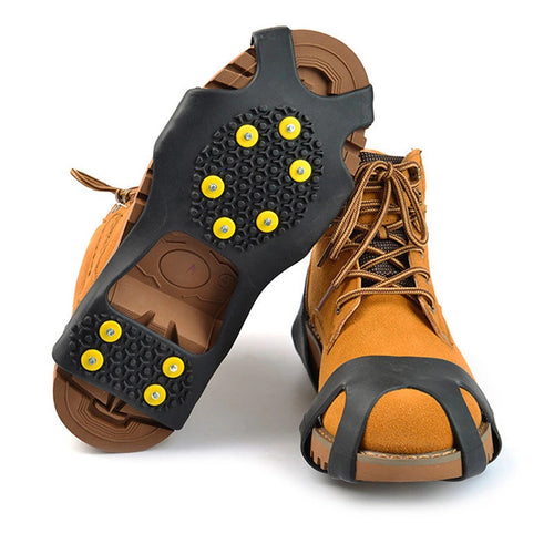 Studded ice grips fitted over brown lace-up boots, showing the metal studs on the sole; boots not included