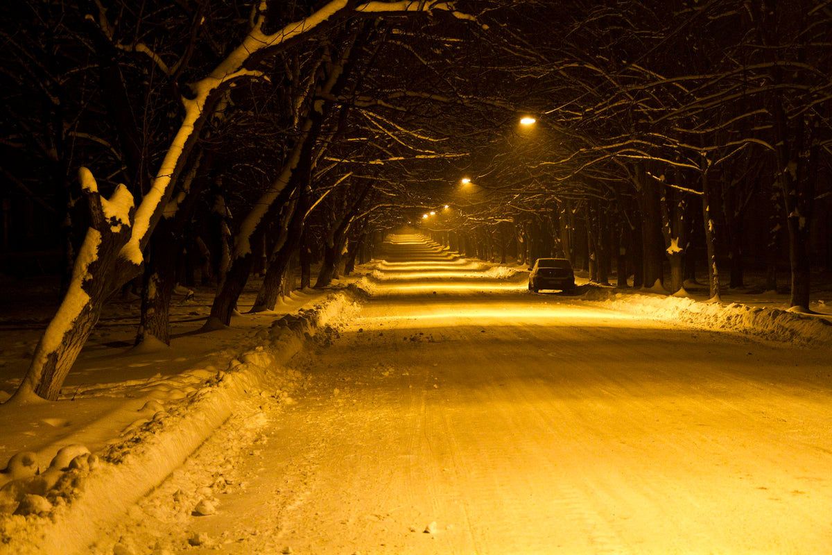 A snowy road at night